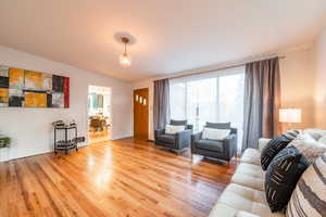 Living room with an inviting chandelier and wood finished floors