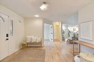 Foyer featuring stairway, baseboards, recessed lighting, and light wood-style flooring