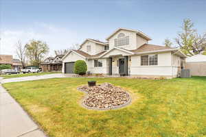 Traditional-style house with a garage, stucco siding, driveway, and a front yard