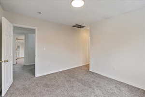 Spare room featuring carpet floors and baseboards