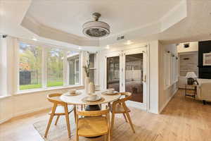 Sunroom / solarium with baseboards, wood finished floors, and a raised ceiling