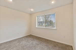 Spare room with baseboards, recessed lighting, and carpet