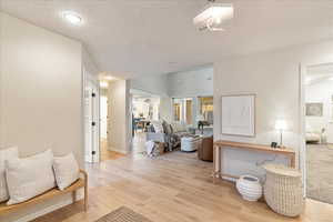 Interior space featuring recessed lighting, baseboards, light wood finished floors, and a textured ceiling