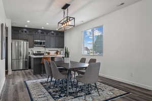 Dining room featuring baseboards, a chandelier, wood finished floors, and visible vents
