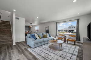 Living room featuring recessed lighting, wood finished floors, and stairway