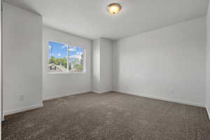 Unfurnished room with carpet floors, a textured ceiling, baseboards, and visible vents