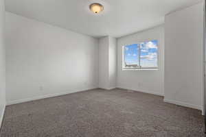 Empty room featuring baseboards and carpet
