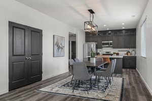Dining space with baseboards, an inviting chandelier, and dark wood finished floors
