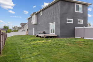 Rear view of house featuring a lawn, a fenced backyard, and french doors