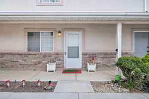 Property entrance featuring brick siding and stucco siding