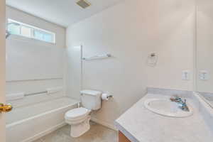 Full bath with tile patterned flooring, bathtub / shower combination, vanity, toilet, and visible vents