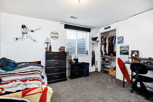 Carpeted bedroom wit a closet