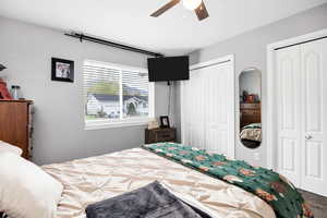 Bedroom featuring a ceiling fan and two closets