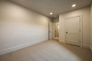 Unfurnished room featuring light colored carpet, recessed lighting, and baseboards