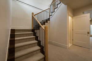 Stairs featuring carpet flooring and baseboards