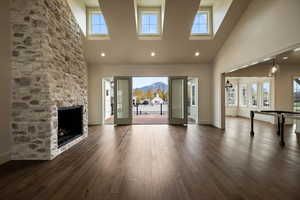 Unfurnished living room with a high ceiling, a fireplace, and dark wood-style flooring