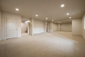 Basement featuring baseboards, recessed lighting, and light colored carpet