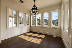Unfurnished sunroom with a chandelier, a mountain view, and visible vents