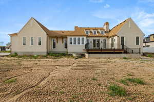 Rear view of property with a wooden deck, a shingled roof, and a chimney