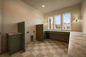 Washroom with electric dryer hookup, hookup for a washing machine, cabinet space, and recessed lighting