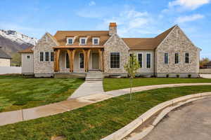 View of front of house with fence, a chimney, a porch, and a front yard
