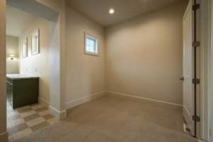 Spare room with baseboards, recessed lighting, and light colored carpet