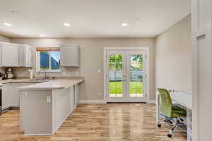 Kitchen featuring french doors, a sink, recessed lighting, and light countertops