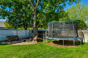 View of yard featuring a fenced backyard and a trampoline