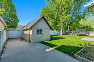 View of outbuilding featuring a fenced backyard, a trampoline, and an outbuilding