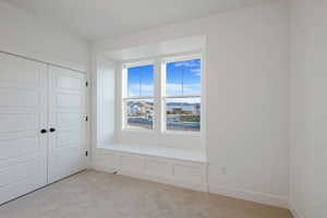 Unfurnished bedroom with light carpet and a closet