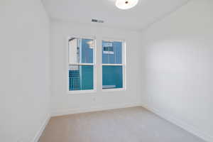 Unfurnished room featuring visible vents, carpet, and baseboards
