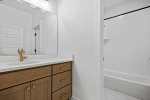Bathroom featuring vanity, marble finish floor, and shower / tub combination
