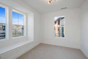 Empty room featuring visible vents and light carpet