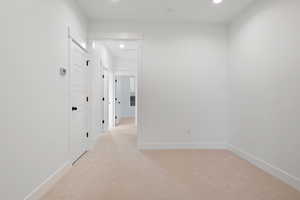 Hall with recessed lighting, baseboards, and light carpet