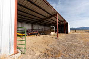 View of pole building featuring a detached carport, a mountain view, and an exterior structure