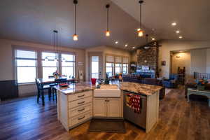 Kitchen featuring ceiling fan, a sink, open floor plan, lofted ceiling, and stainless steel dishwasher