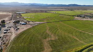 Aerial view of property and surrounding area featuring a mountainous background and rural landscape