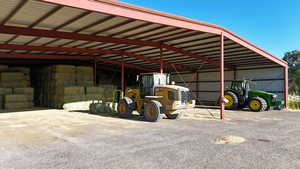 View of parking / parking lot featuring a pole building and a carport