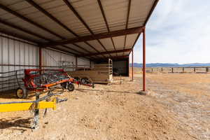 View of yard with an outbuilding, a carport, fence, a pole building, and a mountain view