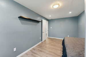 Bedroom featuring recessed lighting, baseboards, a textured ceiling, and light wood-style floors