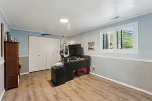 Office featuring visible vents, ornamental molding, baseboards, and wood finished floors
