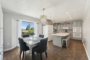 Dining area with crown molding, recessed lighting, baseboards, and a notable chandelier