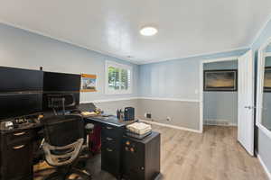 Office with visible vents, ornamental molding, baseboards, and wood finished floors