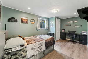 Bedroom featuring crown molding, baseboards, recessed lighting, and wood finished floors