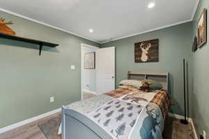Bedroom featuring crown molding, baseboards, and wood finished floors