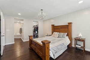 Bedroom featuring baseboards, recessed lighting, dark wood-style flooring, and a chandelier