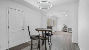 Dining area featuring baseboards, arched walkways, and wood finished floors
