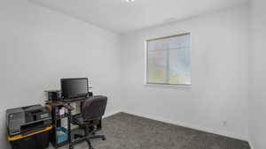 Carpeted office space with baseboards
