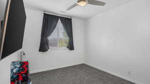 Carpeted spare room featuring baseboards, a ceiling fan, and visible vents