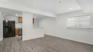 Unfurnished living room featuring light wood-type flooring, recessed lighting, and baseboards